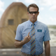 Ryan Reynolds as Guy, wearing his trademark blue shirt and looking confused, in Free Guy.